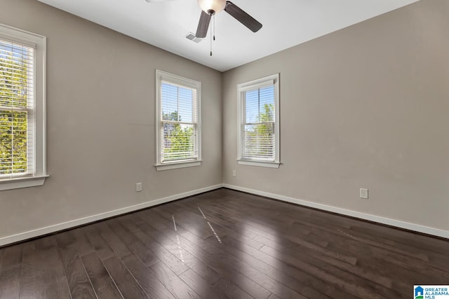 empty room featuring a healthy amount of sunlight, dark hardwood / wood-style floors, and ceiling fan