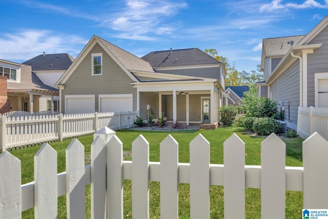 view of front of house featuring a garage, a front lawn, and ceiling fan