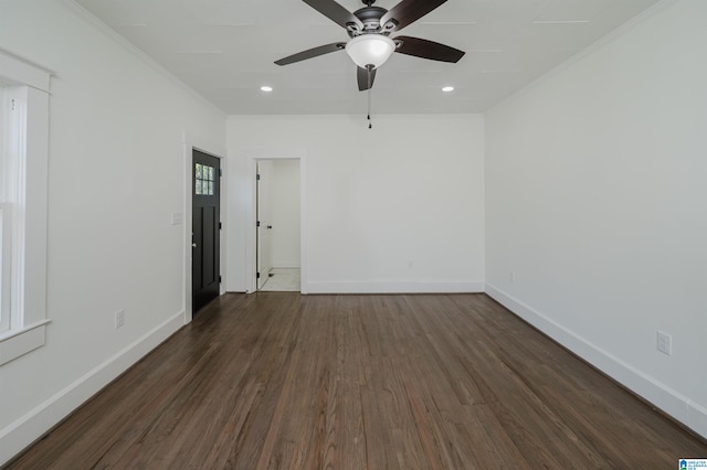 unfurnished room featuring dark wood-type flooring, baseboards, ornamental molding, and ceiling fan