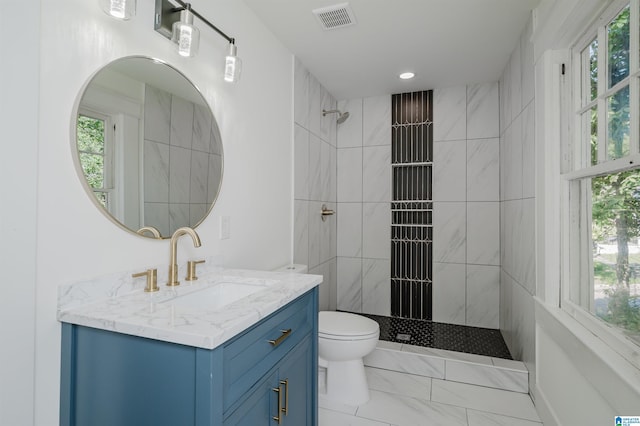 full bathroom featuring visible vents, toilet, tiled shower, and plenty of natural light