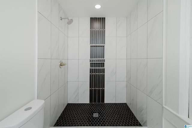 bathroom with tiled shower and toilet