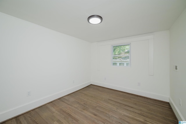 empty room with baseboards and wood finished floors