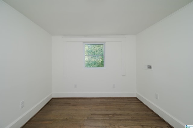 spare room featuring baseboards and wood finished floors