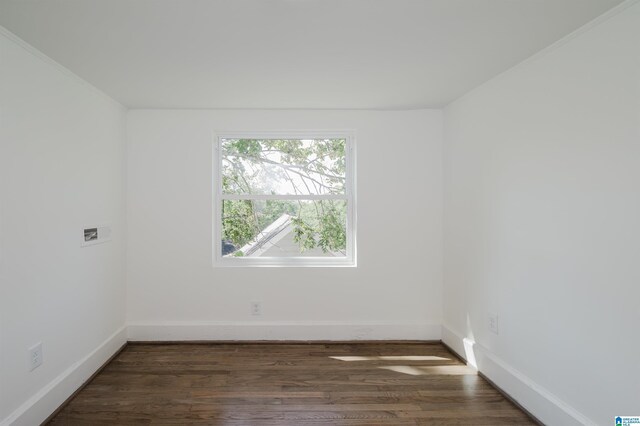 spare room with dark wood-style flooring and baseboards