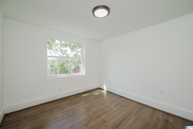 unfurnished room with dark hardwood / wood-style flooring