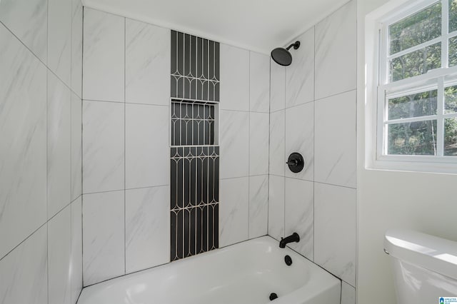 bathroom with toilet and tiled shower / bath