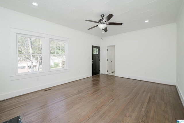 empty room featuring crown molding, dark hardwood / wood-style floors, and ceiling fan