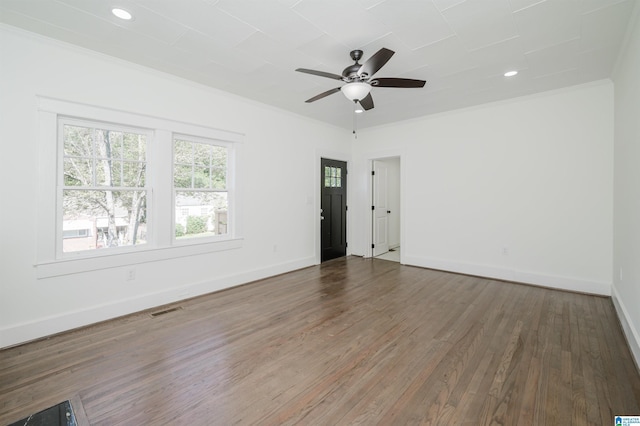 unfurnished room with ornamental molding, visible vents, baseboards, and wood finished floors