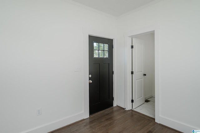 entryway with wood finished floors, baseboards, and ornamental molding