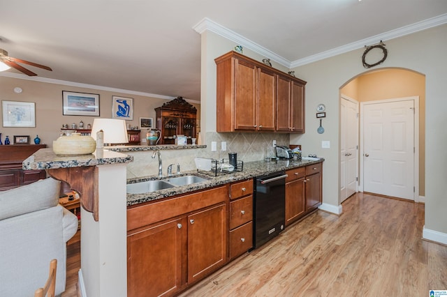 kitchen with sink, kitchen peninsula, dark stone countertops, and a kitchen bar