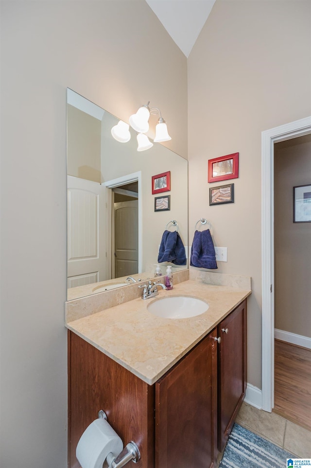 bathroom featuring tile patterned floors, lofted ceiling, and vanity