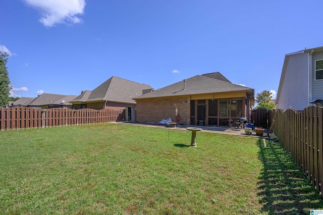 rear view of property featuring a patio area and a yard