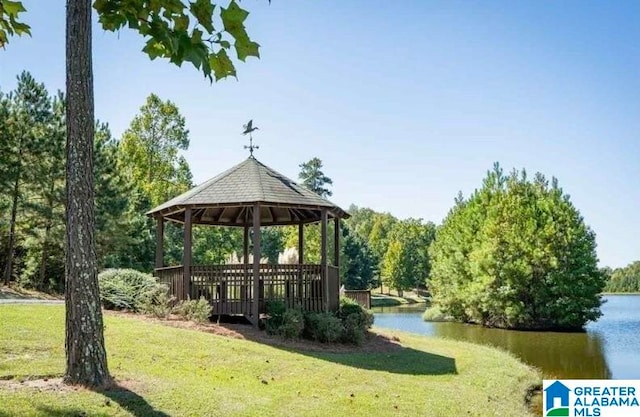 surrounding community with a water view, a gazebo, and a lawn