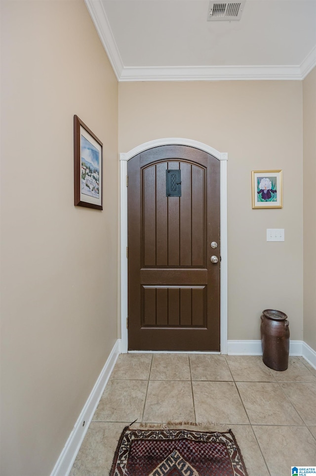 tiled entrance foyer featuring crown molding