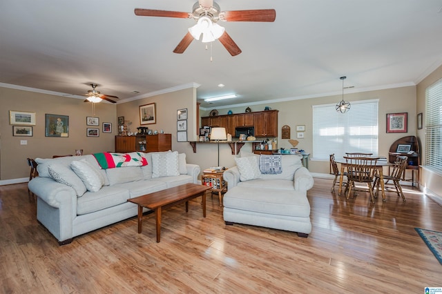 living room featuring ceiling fan, light hardwood / wood-style flooring, and crown molding