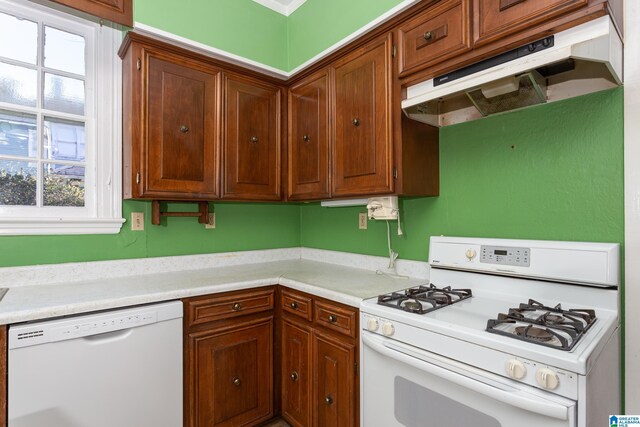 305 S St E, Talladega, AL 35160 - kitchen with under cabinet range hood, light countertops, and white appliances
