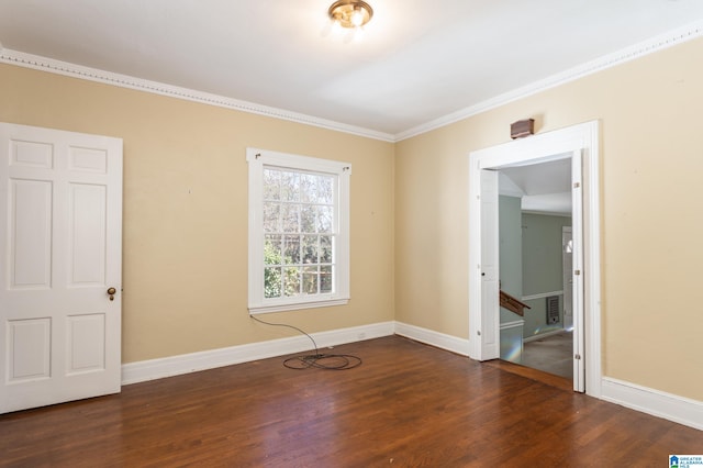 spare room featuring dark hardwood / wood-style floors and crown molding