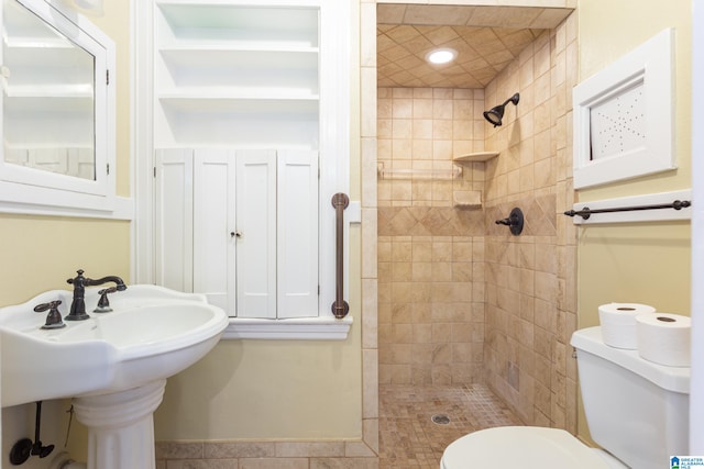 bathroom featuring sink, tile patterned floors, toilet, and tiled shower