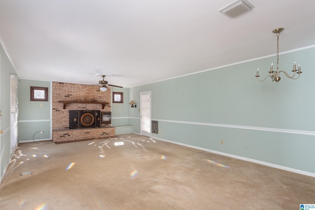 unfurnished living room featuring carpet floors, ceiling fan with notable chandelier, a fireplace, and crown molding