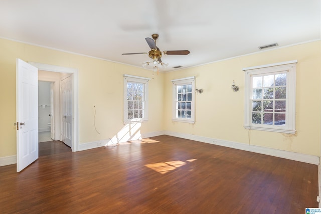 empty room with ceiling fan, ornamental molding, and dark wood-type flooring