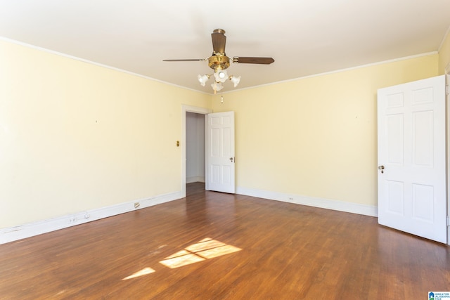 spare room with crown molding, dark hardwood / wood-style floors, and ceiling fan