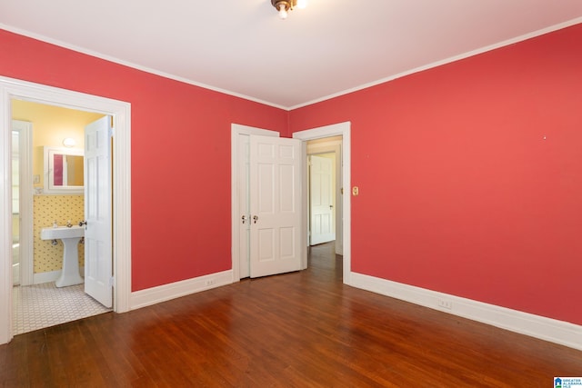 unfurnished bedroom with sink, ensuite bath, dark hardwood / wood-style flooring, and crown molding