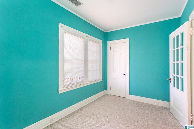 empty room featuring light colored carpet and crown molding