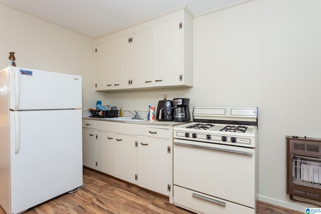 kitchen featuring white cabinets, heating unit, light hardwood / wood-style floors, and white appliances