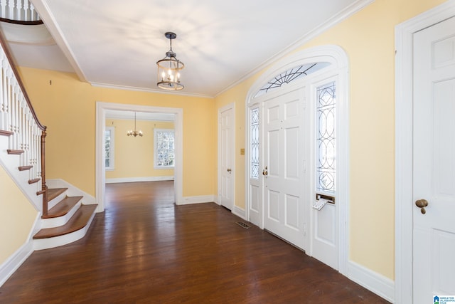 foyer entrance with an inviting chandelier, ornamental molding, and dark hardwood / wood-style flooring