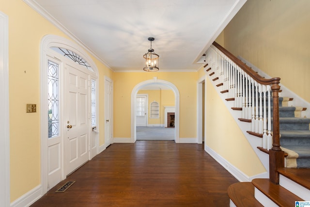 foyer entrance featuring crown molding, dark hardwood / wood-style floors, and a notable chandelier