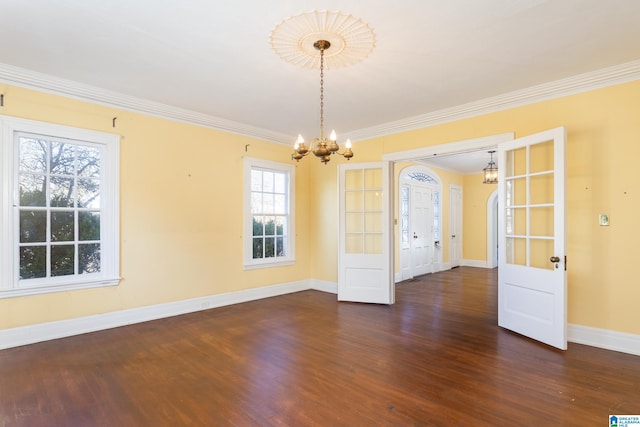 spare room featuring a wealth of natural light, crown molding, and dark hardwood / wood-style flooring