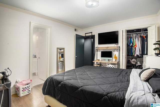 bedroom featuring a closet, ornamental molding, and wood-type flooring