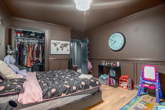 bedroom with ornamental molding, hardwood / wood-style floors, and a closet