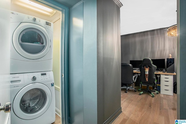 laundry room with light hardwood / wood-style flooring and stacked washer and dryer