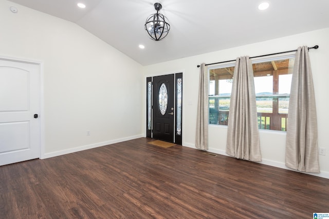 entrance foyer featuring dark wood-type flooring, lofted ceiling, and a chandelier