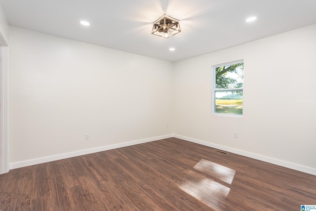 unfurnished room with dark wood-type flooring