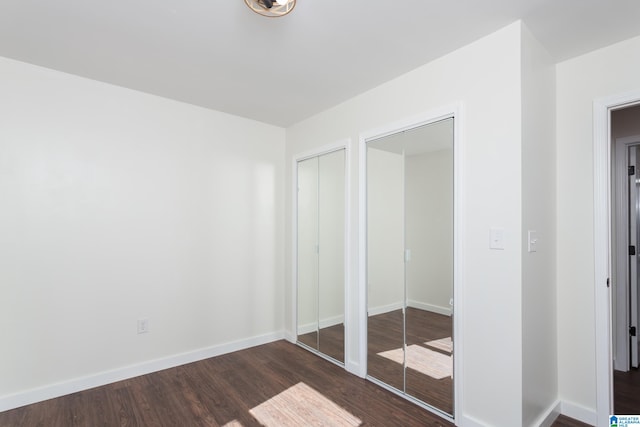 unfurnished bedroom with dark hardwood / wood-style flooring