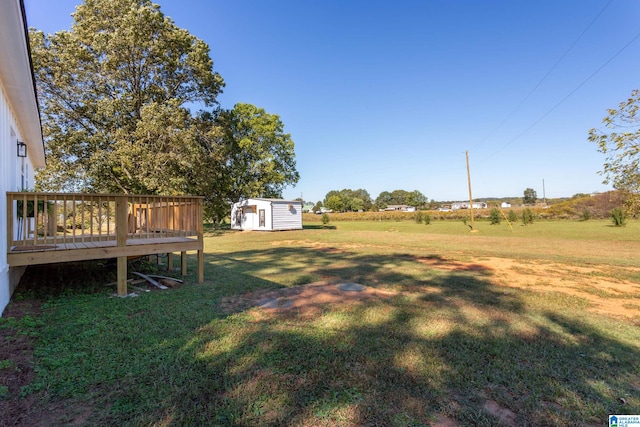 view of yard featuring a storage unit and a deck