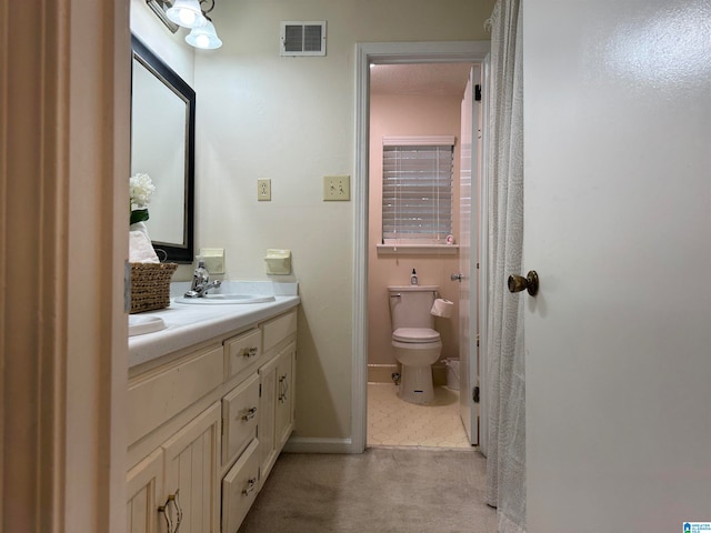 bathroom featuring tile patterned flooring, vanity, and toilet