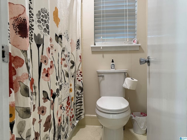 bathroom with walk in shower, tile patterned flooring, and toilet