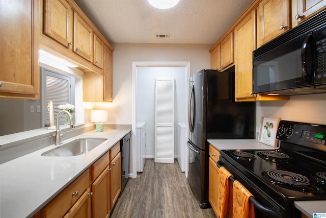 kitchen featuring dark hardwood / wood-style floors, black appliances, a textured ceiling, and sink