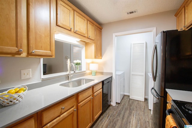 kitchen featuring dishwasher, a textured ceiling, dark wood-type flooring, and sink