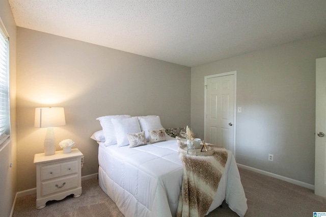 carpeted bedroom featuring a textured ceiling