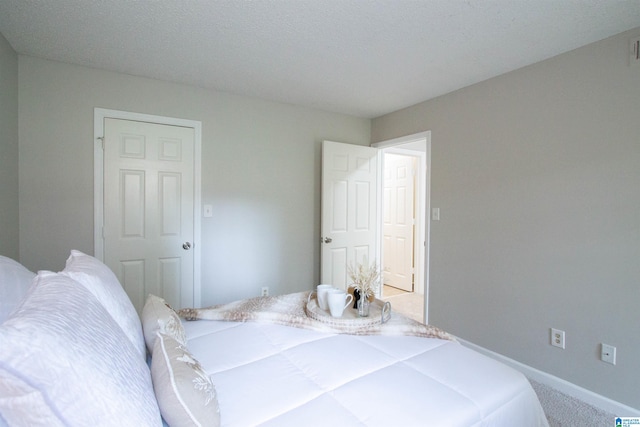 bedroom with a textured ceiling and carpet flooring