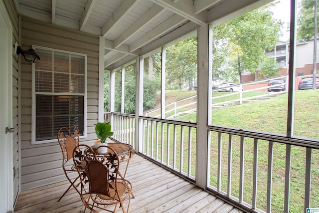 unfurnished sunroom featuring wooden ceiling, beamed ceiling, and a wealth of natural light