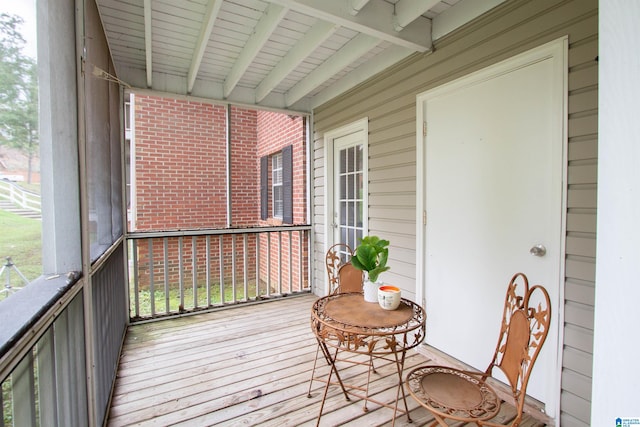 sunroom with a healthy amount of sunlight and beam ceiling