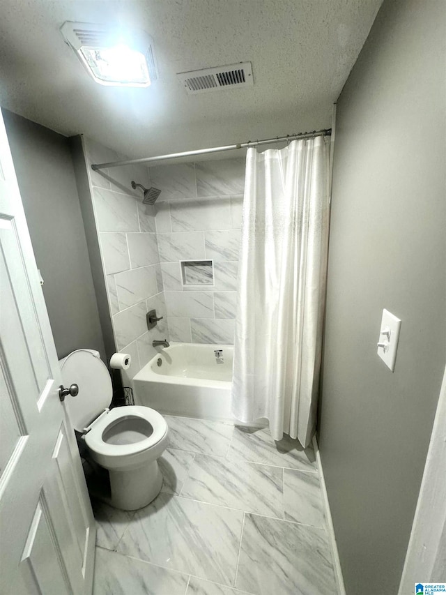 bathroom featuring a textured ceiling, shower / tub combo, and toilet