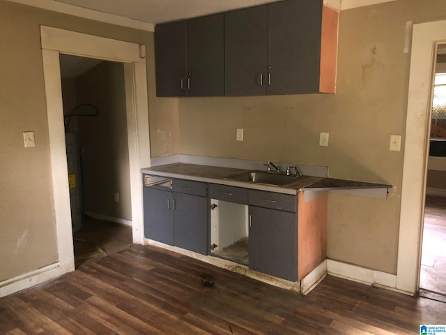 kitchen with water heater, sink, and dark hardwood / wood-style flooring