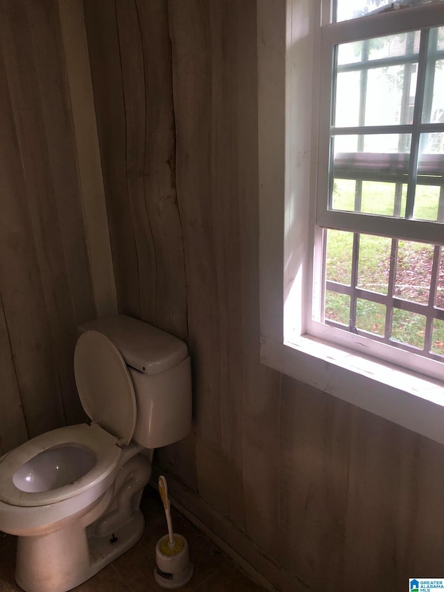 bathroom with wooden walls and toilet