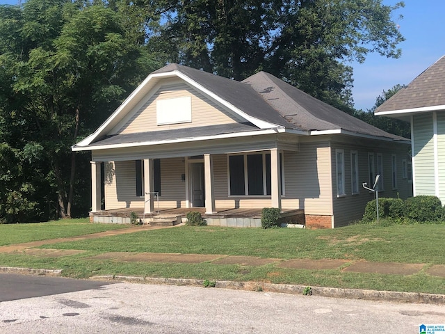 view of front of house featuring covered porch and a front yard